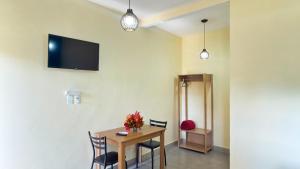 a dining room with a table and a tv on the wall at Pousada Iandara in Pirenópolis