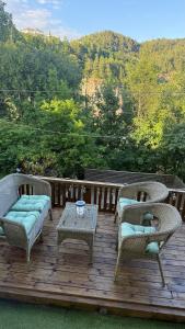 two wicker chairs and a table on a wooden deck at Koselig leilighet in Flekkefjord +4 photos