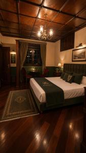 a bedroom with a large bed and a chandelier at Kinsale Suites in Nettuno