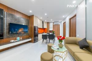 a living room with a couch and a table at PinkyRiver in Danang +4 photos