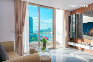 a living room with a couch and a large window at PinkyRiver in Danang