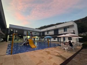 a large building with a pool with a playground at Hotel villa dulce campestre in Melgar