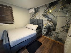 a small bedroom with a bed and a wall at Arriendo habitaciones Talca in Talca