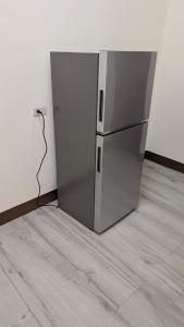 a stainless steel refrigerator in the corner of a room at Ronglai Inn in Jinning