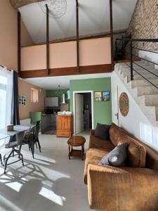 a living room with a couch and a table at Les nids de la chevêche in Saint-Pierre-de-Juillers