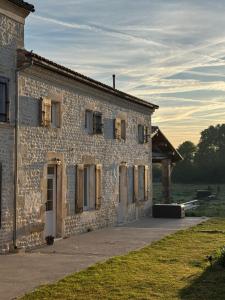 an old stone building with a door and windows at Les nids de la chevêche in Saint-Pierre-de-Juillers