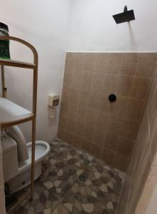 a bathroom with a toilet and a tile floor at Tu hostalito en Parras in Santa Isabel