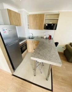 a kitchen with a table and a refrigerator at Departamento Centro Chillán in Chillán