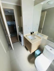 a bathroom with a toilet and a sink and a mirror at Departamento Centro Chillán in Chillán