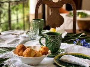 a table with a white bowl of food and green cups at Segredo da Serra Pousada Boutique in Tiradentes +77 photos