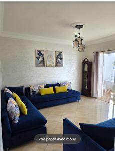 a living room with a blue couch and yellow pillows at Oualidia résidence Ben zeroual in Oualidia +4 photos
