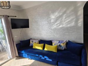 a blue couch with yellow pillows in a living room at Oualidia résidence Ben zeroual in Oualidia