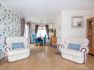 a living room with two chairs and a table at Caledon in Aviemore
