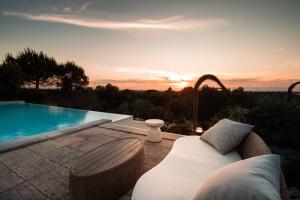 a couch sitting on a patio next to a swimming pool at Monte da Casa Telhada in Santiago do Cacém