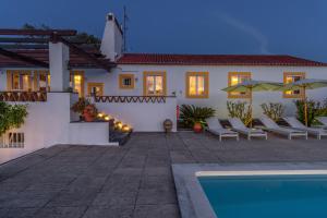 a villa with a swimming pool at dusk at Monte da Casa Telhada in Santiago do Cacém