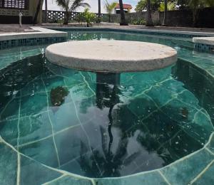 a swimming pool with a table in the water at Bluehaven Austin House in La Paz