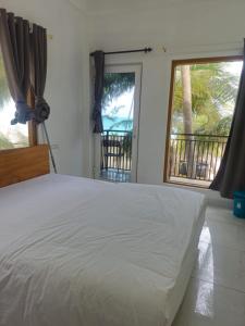 a bedroom with a white bed and a large window at La Paraso Agatti in Agatti +98 photos
