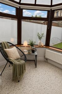 a room with a chair and a table and windows at Ardee Retreat - Sleeps 6, Garden, Walk to Town in Ardee +39 photos