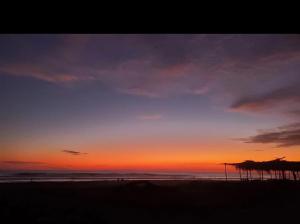 a sunset on a beach with the ocean at Bluehaven Austin House in La Paz +2 photos