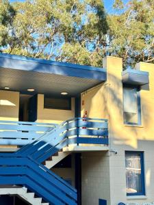 a house with a blue staircase on the side of it at Pathfinder Motel in Melbourne +2 photos