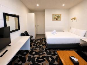 a hotel room with a bed and a flat screen tv at Pathfinder Motel in Melbourne