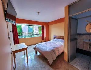 a bedroom with a bed and a sink and a window at Hostal Huagancu in Huari