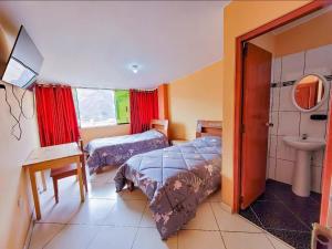 a bedroom with a bed and a sink and a toilet at Hostal Huagancu in Huari