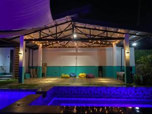 a room with a pool with purple lights at Kia Ora Villa Staycation in Los Baños