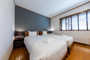 a bedroom with two beds and a window at Kiseki in Kutchan