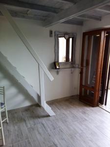 an empty room with a staircase and a window at Appartamento Scirocco in Marina di Campo