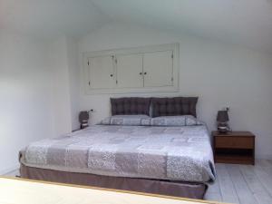 a bedroom with a large bed and a white wall at Appartamento Scirocco in Marina di Campo
