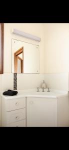 a white bathroom with a sink and a mirror at Waves & Wildlife Cottages Kangaroo Island in Stokes Bay +43 photos