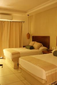 a hotel room with two beds and a window at Hotel Boutique Kasa Sara in San Patricio Melaque