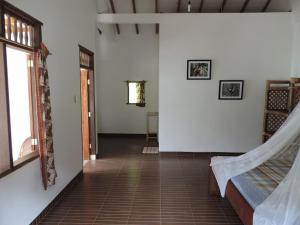 a hallway of a house with a room with white walls at Riverside Guesthouse in Bukit Lawang