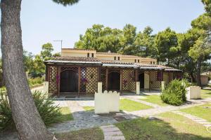 ein Haus in einem Park mit einem Baum in der Unterkunft Domus Budoni 1 in Budoni