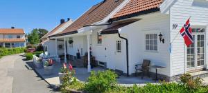 a white house with a flag on the side of it at Highly recommended Apartment Trymsvei in Kristiansand