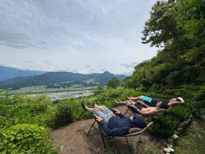 a group of people laying in lawn chairs on a hill at Saunalodge 白道 in Minami Uonuma +6 photos