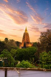 a building with a tower in front of a sunset at 3 Sixty House in Bodh Gaya