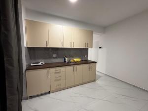 a kitchen with white cabinets and a tile floor at Apartmani B&A in Ulcinj +2 photos