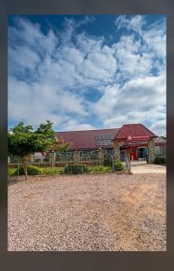 a barn with a red roof and a tree in front of it at RockView Hotel in Tongo