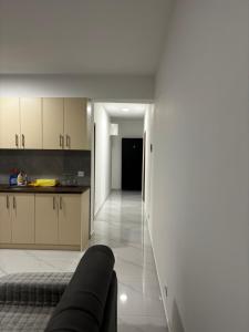 a kitchen with white cabinets and a couch in a room at Apartmani B&A in Ulcinj
