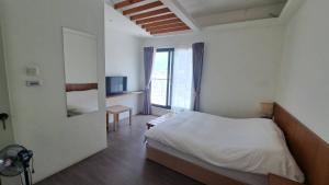a bedroom with a bed and a room with a window at Bai Ji Yi B&B in Hengchun South Gate +43 photos