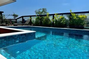 a swimming pool with blue water in a building at Harmonie apto requintado | Centro | 200m do mar in Itapoa