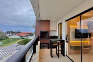a balcony with a table and a view of a street at Harmonie apto requintado | Centro | 200m do mar in Itapoa