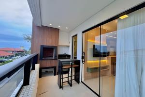 a balcony with a bar and a kitchen with a view at Harmonie apto requintado | Centro | 200m do mar in Itapoa