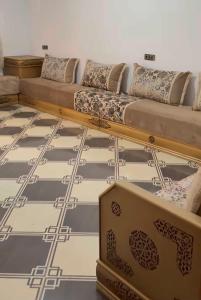 a living room with a couch and a checkerboard floor at Casa de nordin in Fnidek