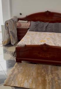 a bedroom with a wooden bed and a rug at Casa de nordin in Fnidek