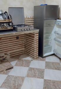 a kitchen with a stove and a refrigerator at Casa de nordin in Fnidek