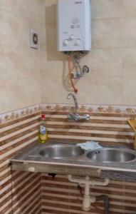 a kitchen sink with a soap dispenser above it at Casa de nordin in Fnidek