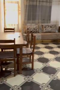 a living room with a table and chairs and a couch at Casa de nordin in Fnidek